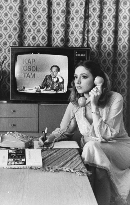 Rák Kati színésznő, háttérben a televízió képernyőjén Vitray Tamás, 1979 (Fortepan / Rádió és Televízió Újság)