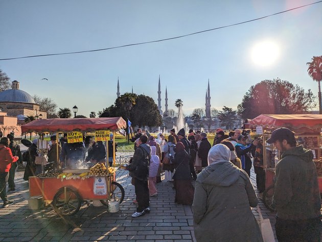 Sült kukoricát vagy gesztenyét szinte bárhol vásárolhatunk az utcai árusoktól, akik elmaradhatan szereplői a városi életképnek (a háttérben a Kék mecset minaretjei)