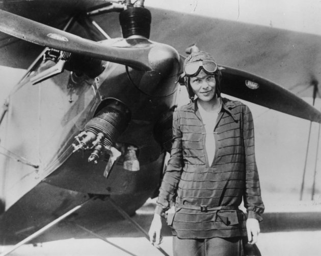 Ameila Earhart, háttérben repülőgéppel. Korabeli fotó