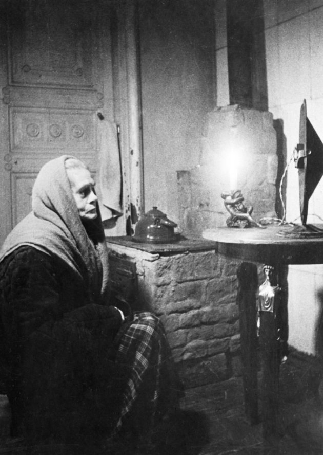 Az éhség által gyötört nő a rádió előtt ülve figyel valahol Leningrádban az ostrom idején