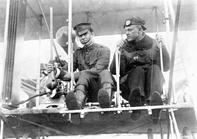Myron Crissy hadnagy a kezében tartja az első bombát, amelyet nem sokkal a kép elkészülte után dobott le a mellette ülő Philip Parmalee által vezetett repülőgépről